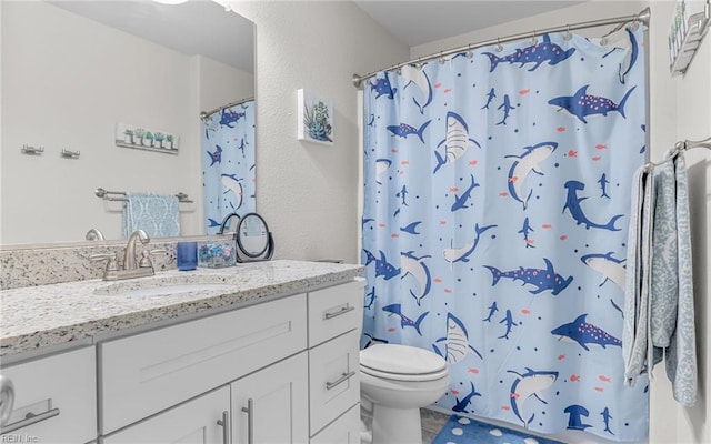 bathroom featuring toilet, a textured wall, a shower with shower curtain, and vanity