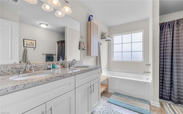 bathroom with a garden tub, double vanity, a sink, and tile patterned floors