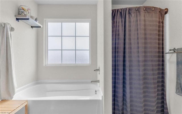 bathroom with curtained shower and a garden tub