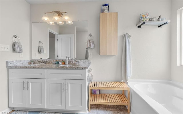 bathroom with double vanity, a sink, and a bath