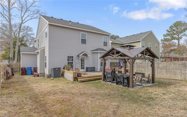 back of property with a lawn, a gazebo, central AC unit, a deck, and a fenced backyard