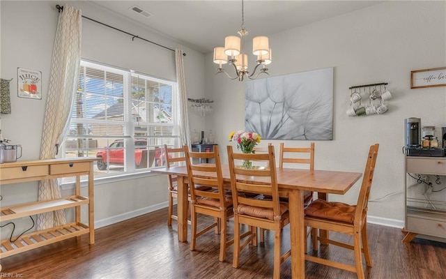 dining space with visible vents, baseboards, a chandelier, and wood finished floors