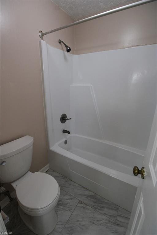 full bath with toilet, marble finish floor, shower / bath combination, and a textured ceiling