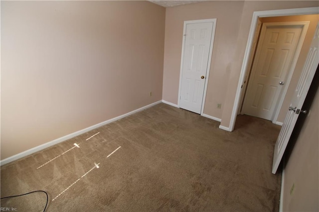 unfurnished bedroom with carpet floors and baseboards