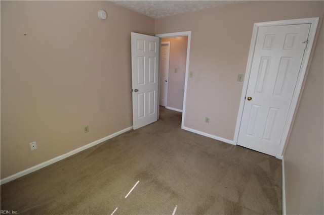 unfurnished bedroom with carpet flooring and baseboards