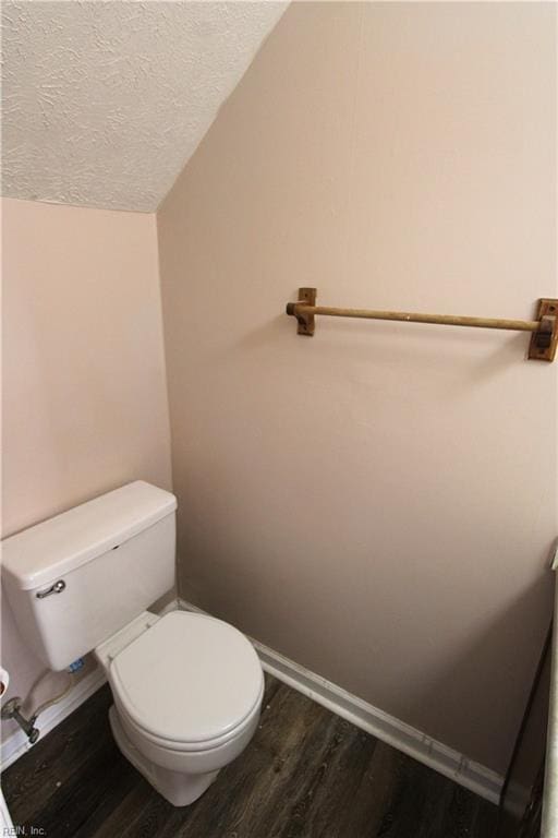 bathroom featuring toilet, a textured ceiling, baseboards, and wood finished floors