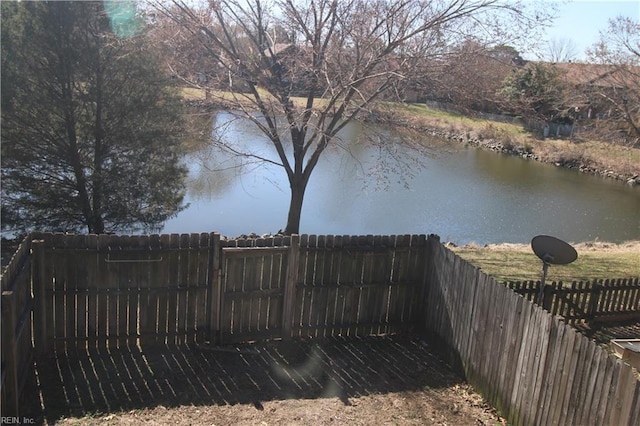 view of yard with a water view and fence