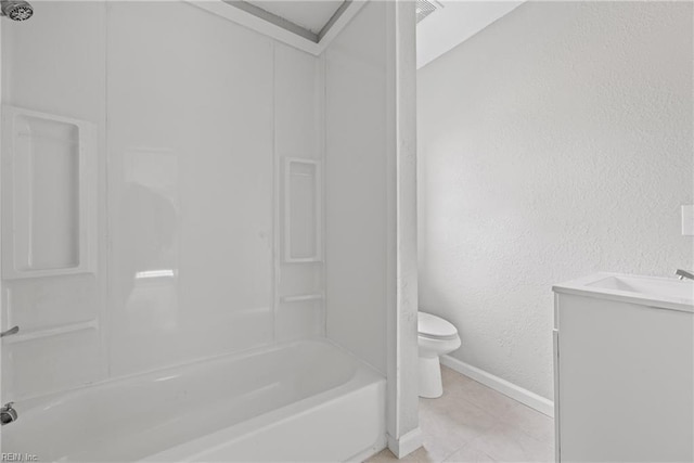 bathroom featuring baseboards, toilet, bathing tub / shower combination, a textured wall, and vanity