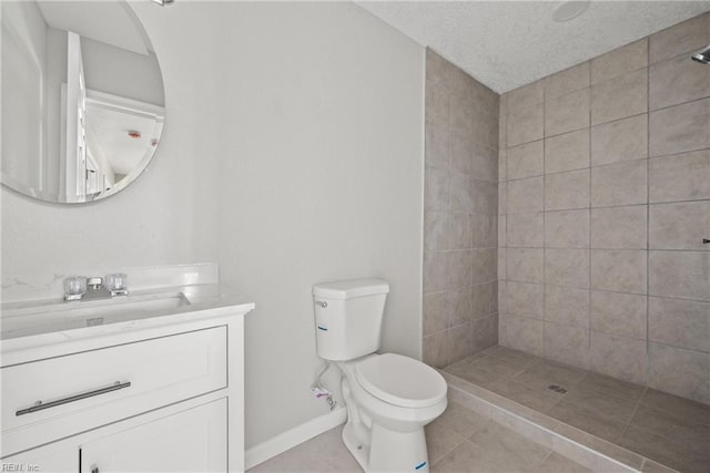 full bath featuring vanity, a textured ceiling, toilet, and tiled shower