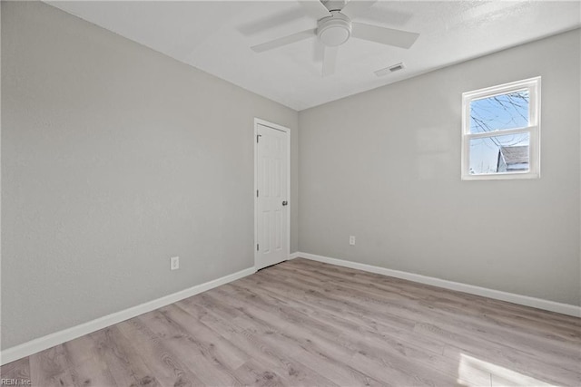 unfurnished room featuring ceiling fan, visible vents, baseboards, and wood finished floors