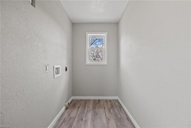 clothes washing area with baseboards, light wood-type flooring, laundry area, hookup for a washing machine, and electric dryer hookup