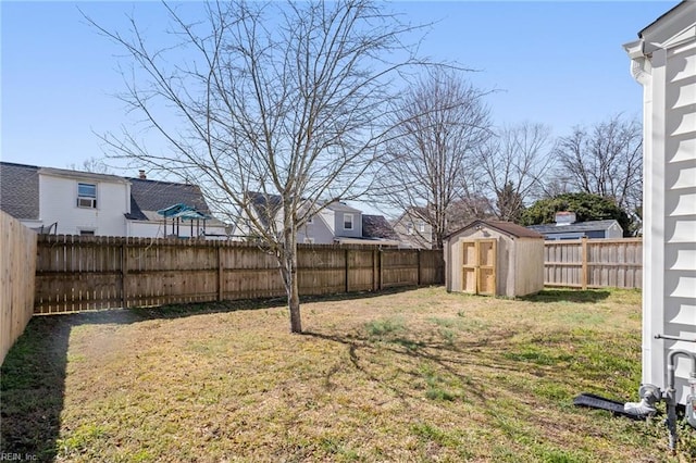view of yard featuring a fenced backyard, an outdoor structure, and a storage shed