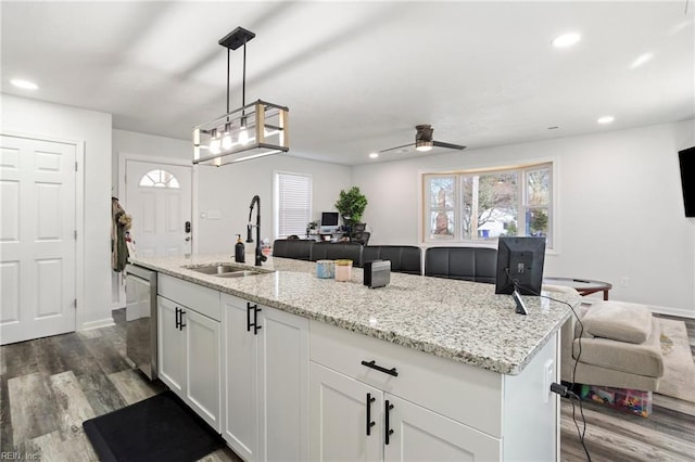 kitchen with dark wood-style flooring, a sink, white cabinetry, stainless steel dishwasher, and recessed lighting