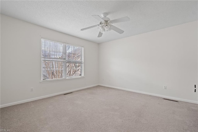 spare room with carpet floors, ceiling fan, and a textured ceiling