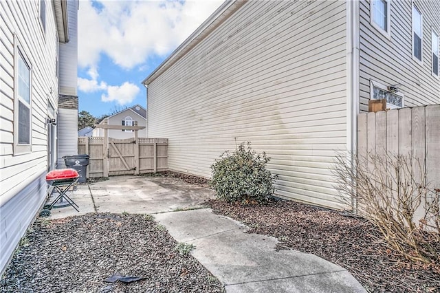 view of home's exterior with fence and a patio