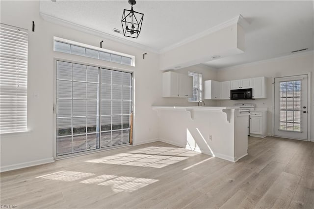 kitchen with white cabinetry, crown molding, black microwave, and a breakfast bar area