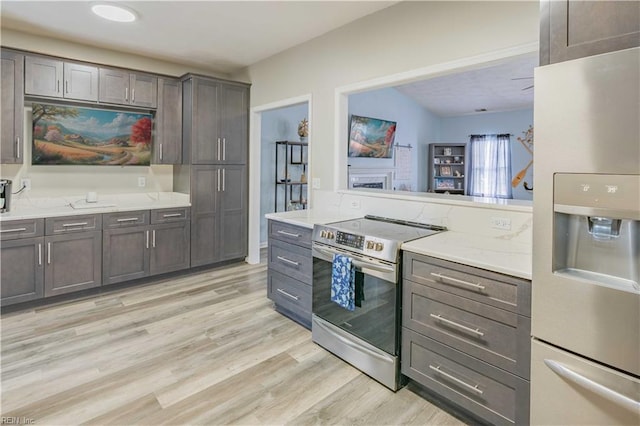 kitchen featuring stainless steel appliances, light wood-style flooring, and dark brown cabinetry