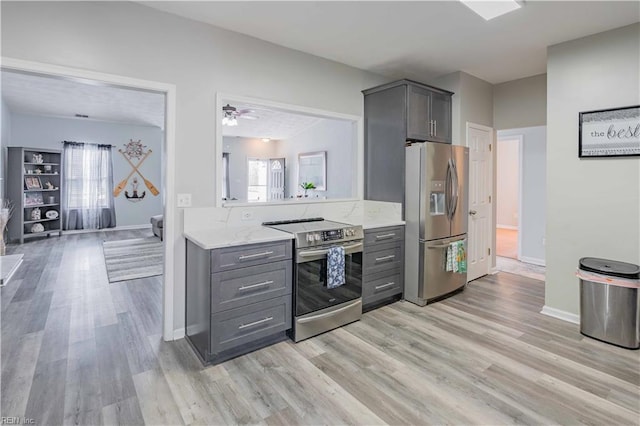 kitchen with gray cabinets, appliances with stainless steel finishes, light wood-style floors, a ceiling fan, and baseboards