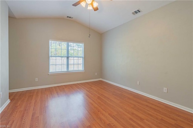 unfurnished room with light wood finished floors, visible vents, a ceiling fan, vaulted ceiling, and baseboards