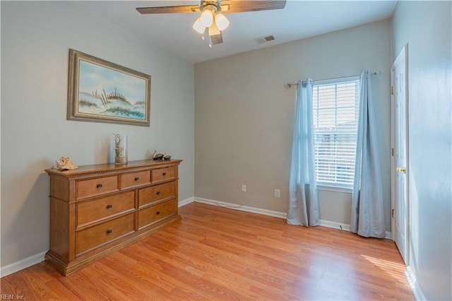 bedroom with light wood finished floors, a ceiling fan, visible vents, and baseboards