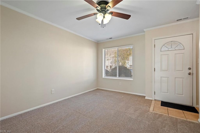 carpeted foyer featuring a ceiling fan, visible vents, crown molding, and baseboards