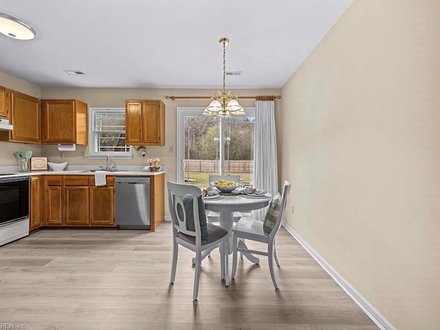 kitchen featuring a notable chandelier, baseboards, electric stove, stainless steel dishwasher, and light countertops