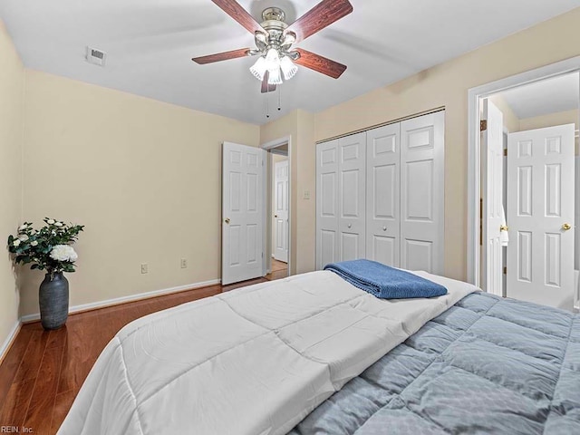 bedroom with baseboards, visible vents, a ceiling fan, wood finished floors, and a closet