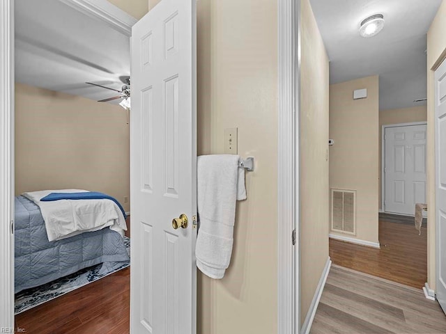 ensuite bathroom featuring ceiling fan, ensuite bath, wood finished floors, and visible vents