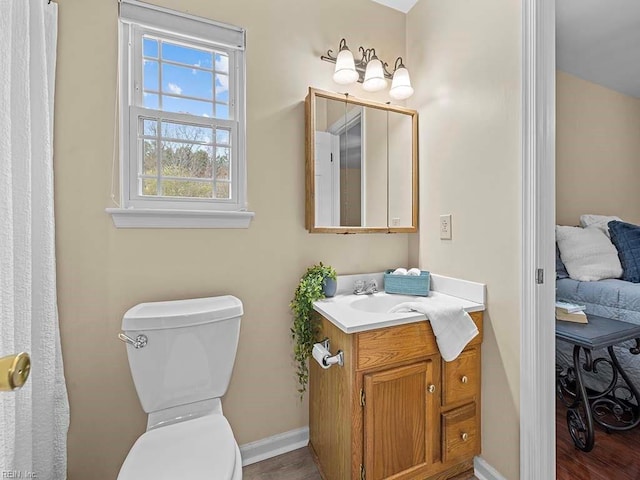 bathroom featuring wood finished floors, vanity, toilet, and baseboards