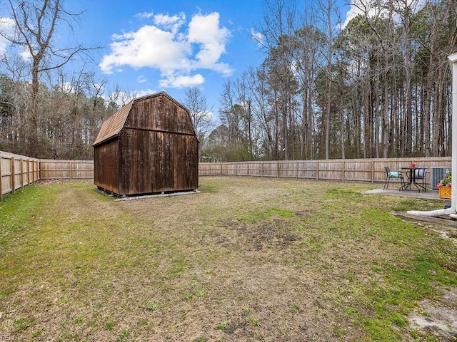 view of yard with an outbuilding, a patio, central AC unit, a shed, and a fenced backyard