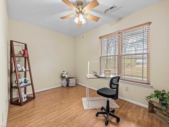 office with baseboards, visible vents, and wood finished floors