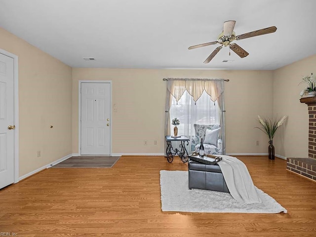 sitting room with visible vents, ceiling fan, baseboards, and wood finished floors