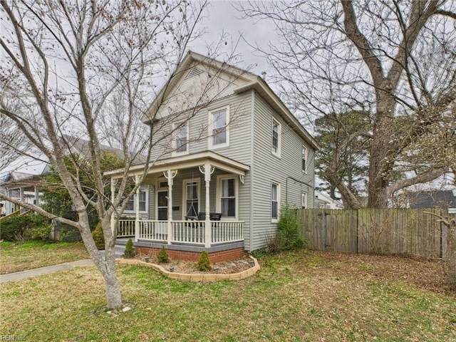 view of front of home with a front lawn, fence, and a porch