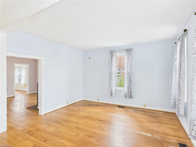 spare room with plenty of natural light, visible vents, and light wood-style floors