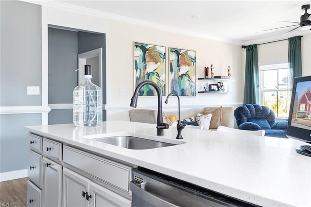 kitchen featuring open floor plan, white cabinetry, crown molding, and a sink