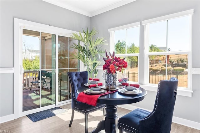 dining area featuring ornamental molding, baseboards, and wood finished floors