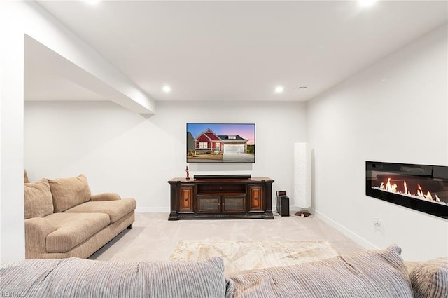 living room featuring recessed lighting, baseboards, light carpet, and a glass covered fireplace