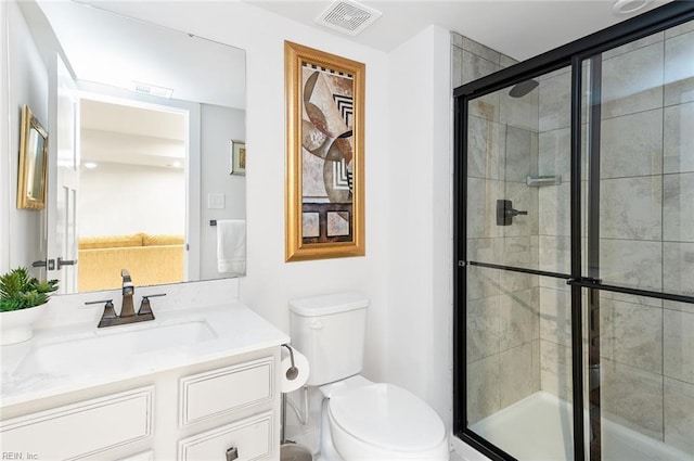 bathroom featuring vanity, toilet, visible vents, and a stall shower