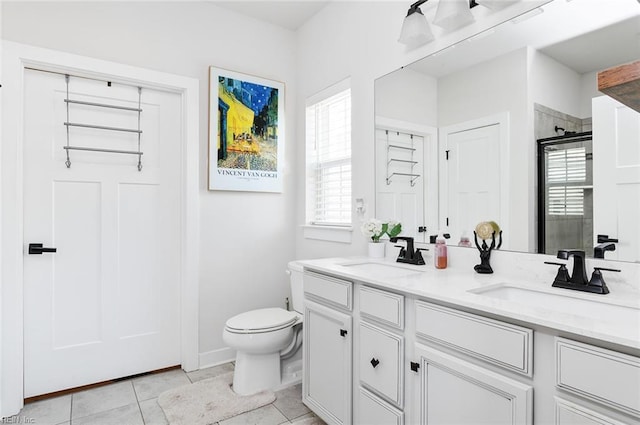 bathroom featuring a sink, a shower with shower door, tile patterned floors, and toilet