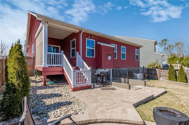 back of house featuring a lawn, a patio, and a fenced backyard