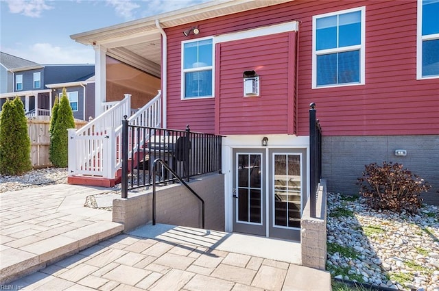 rear view of property with french doors, stairs, a patio, and fence