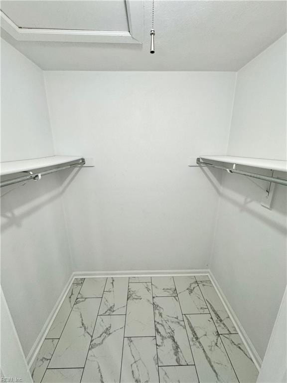 walk in closet with marble finish floor