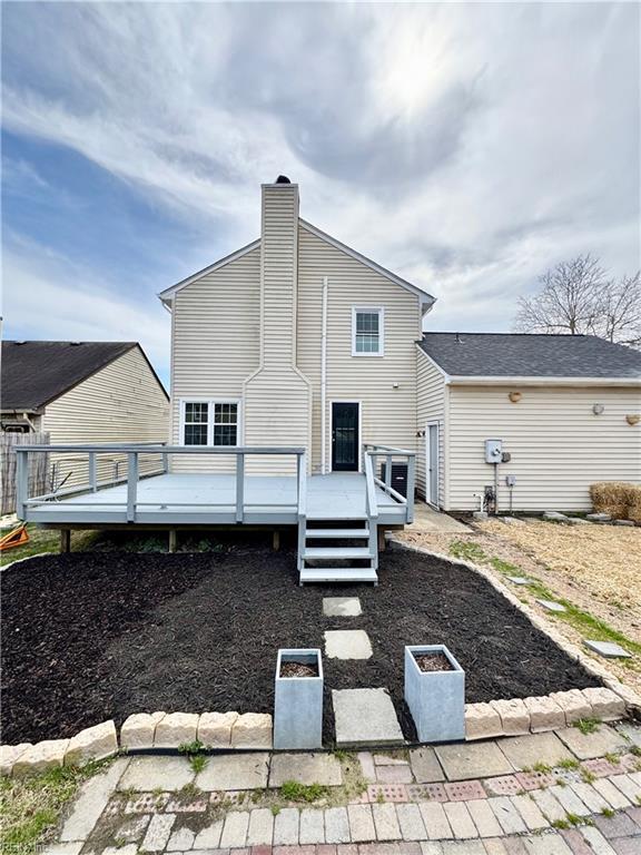 rear view of house with a chimney and a deck