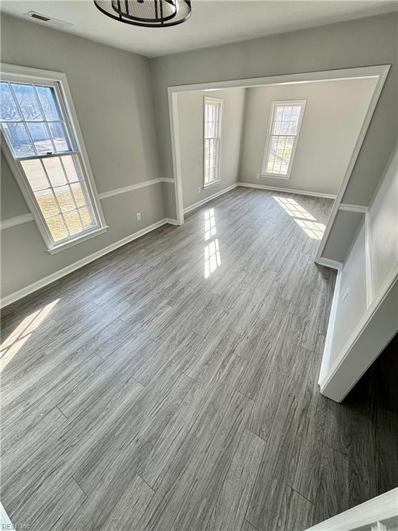 interior space with visible vents, baseboards, and wood finished floors