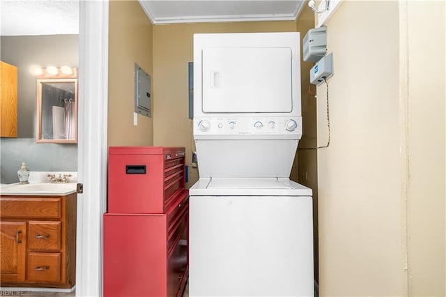 clothes washing area featuring stacked washing maching and dryer, a sink, and electric panel