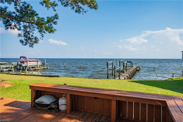 dock area featuring a water view, boat lift, and a yard