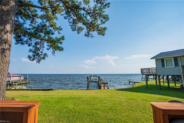 view of yard featuring a dock, a water view, and boat lift