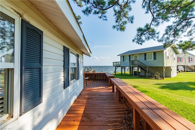 wooden deck with a yard and a water view