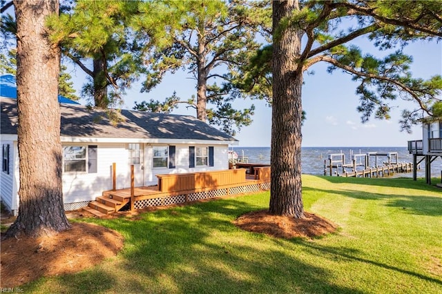 rear view of house featuring a lawn and a deck with water view