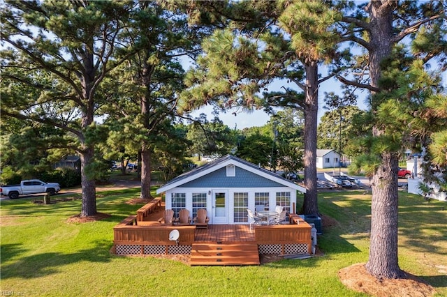 back of property featuring a deck and a lawn